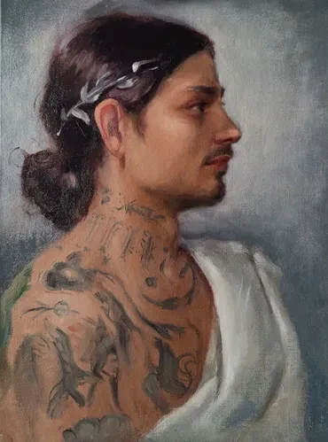 Profile portrait of a man with tattoos and dark hair