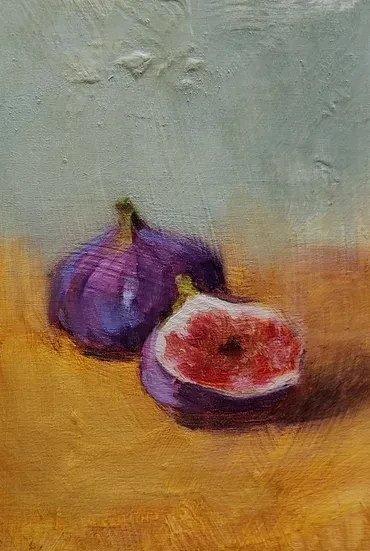 Still life of two figs, one cut open, on a warm ochre ground